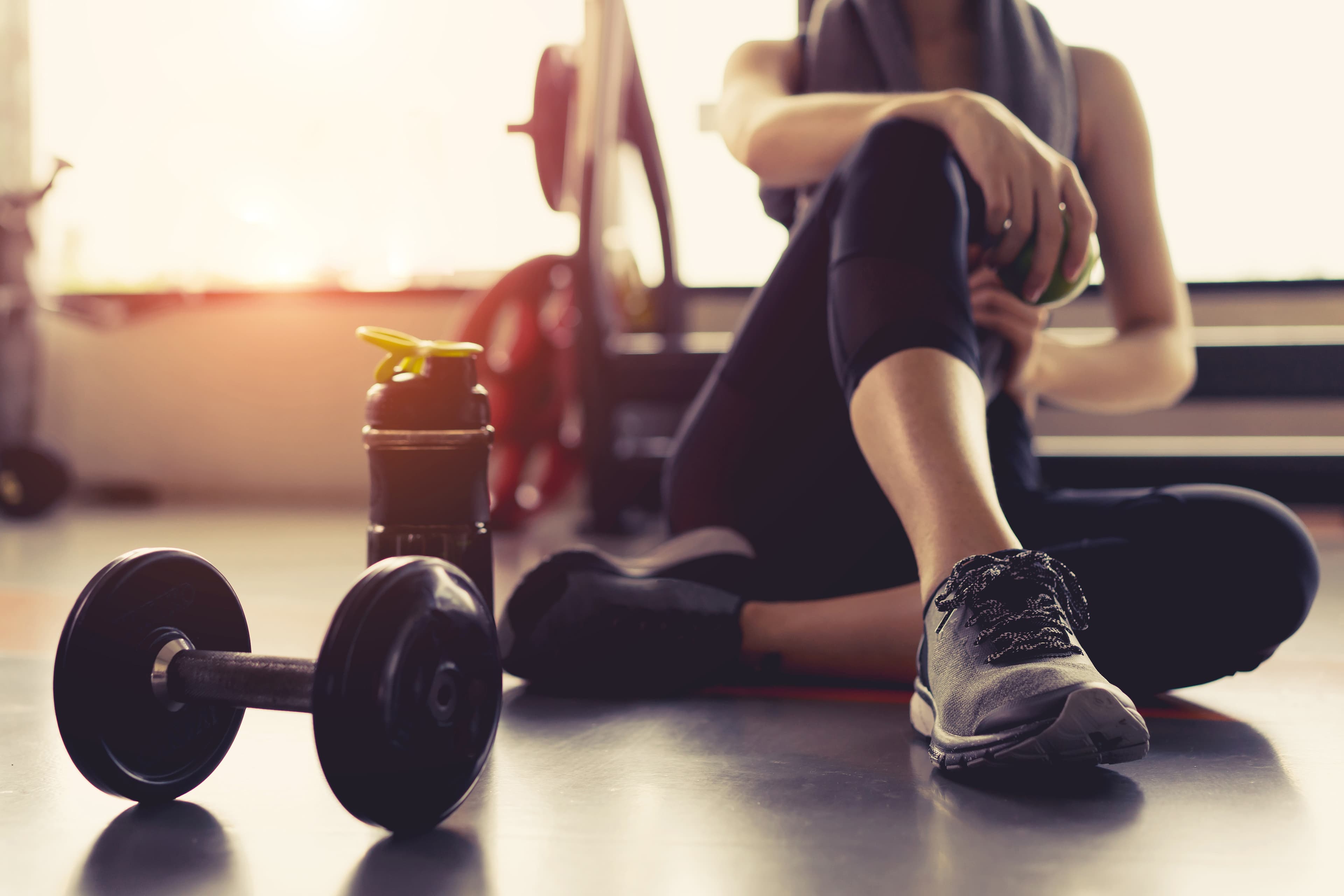 Woman relaxing during a workout with dumbells