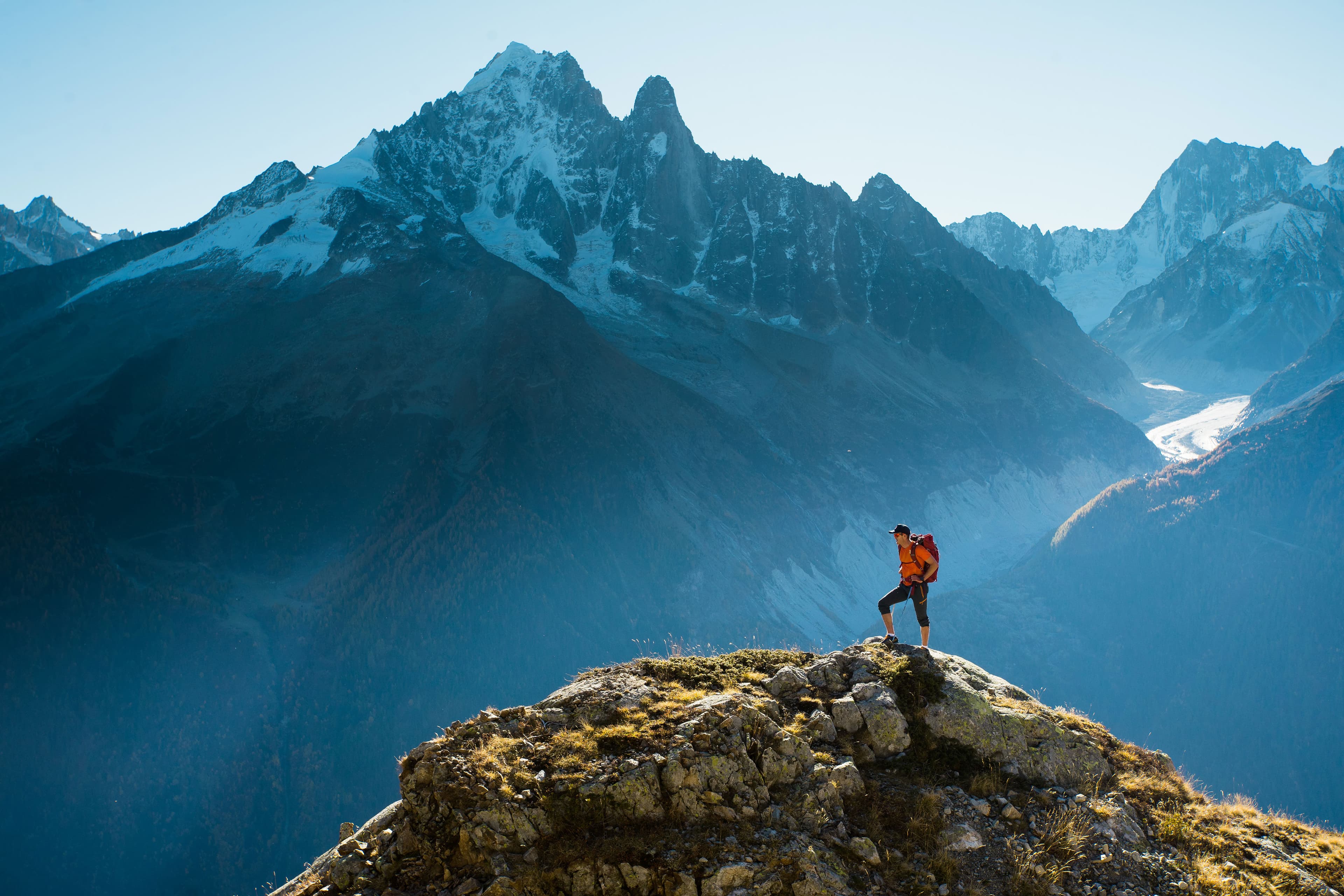 Hiker reaching the summit in the alps