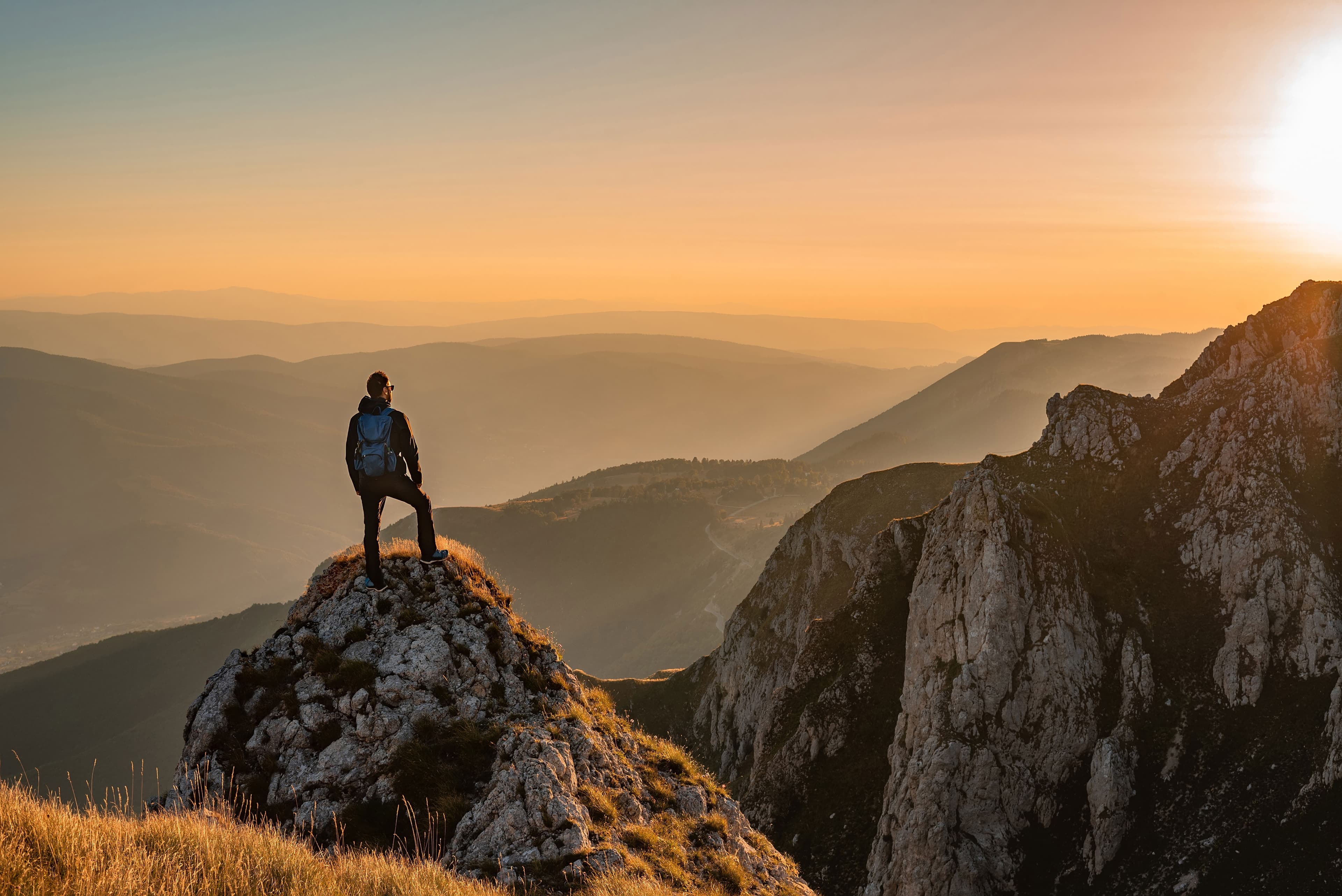 Hiker admiring the sunset from a rocky peak